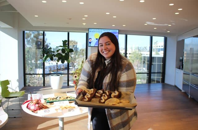 TaxRise employee proudly shows off cookies in competition