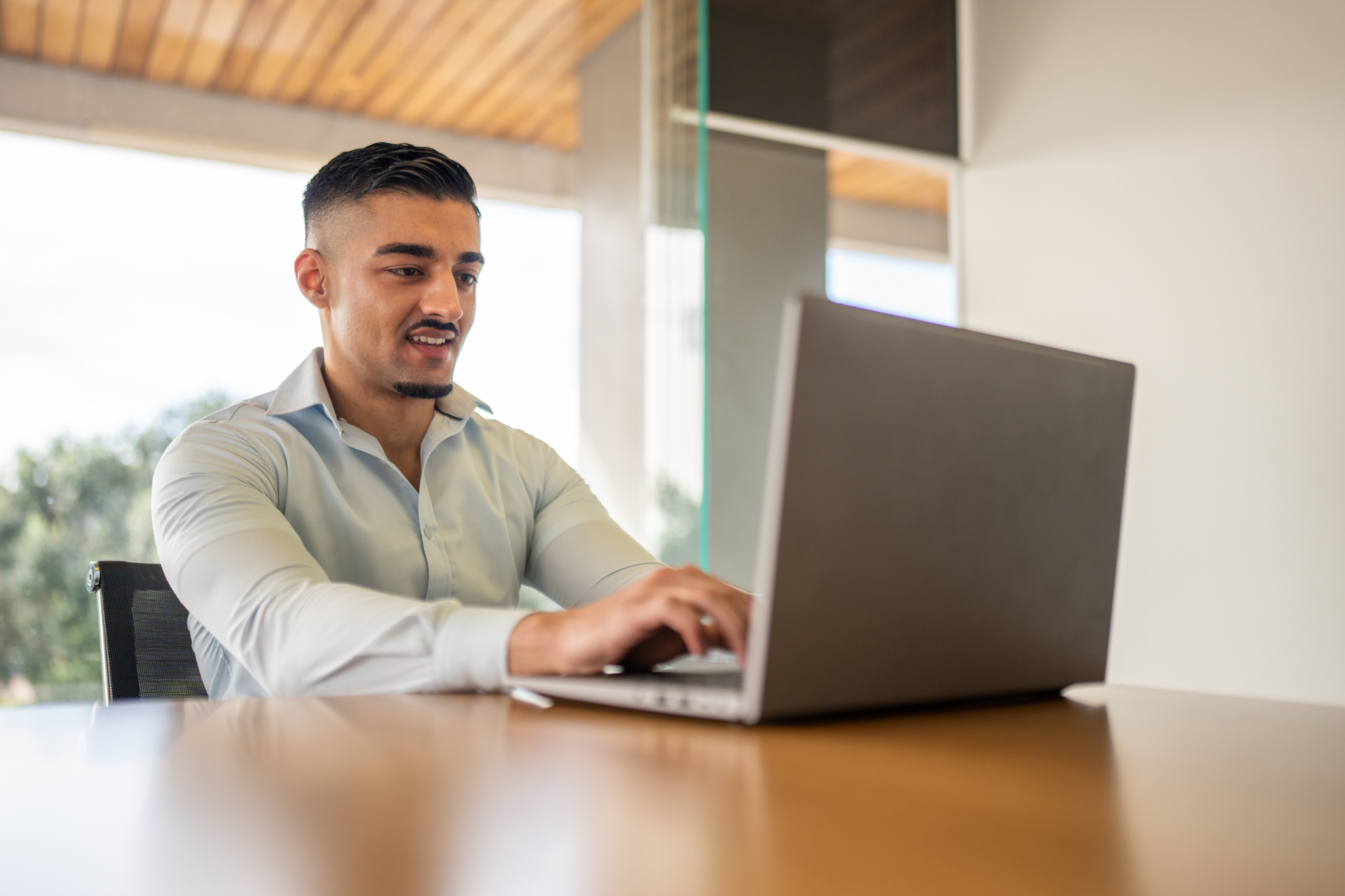 Young Real Estate Agent Working on a Laptop