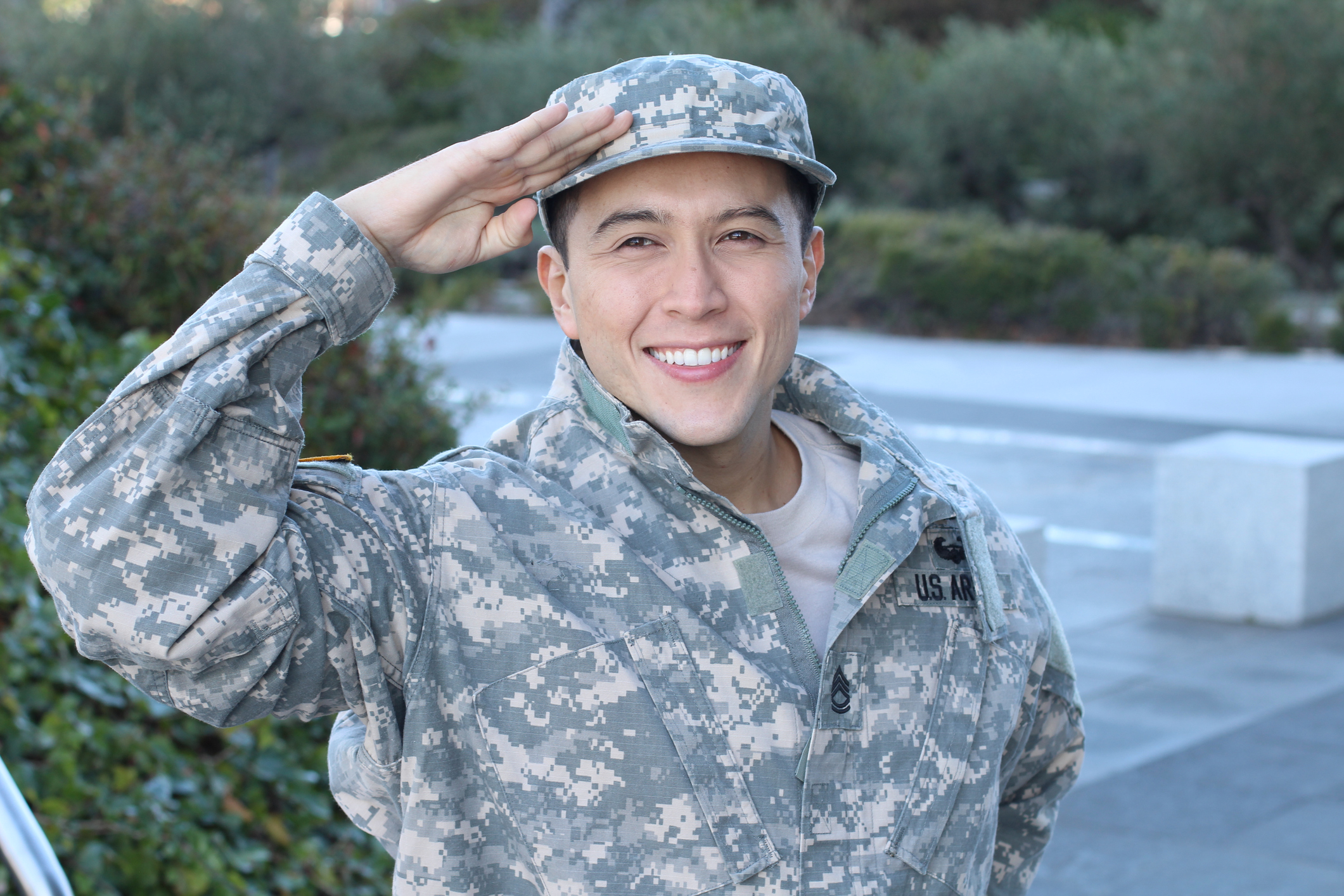 Cheerful military veteran saluting