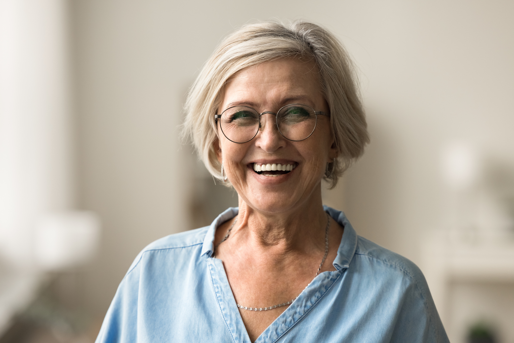 Cheerful elder woman in elegant glasses smiling after resolving tax debt