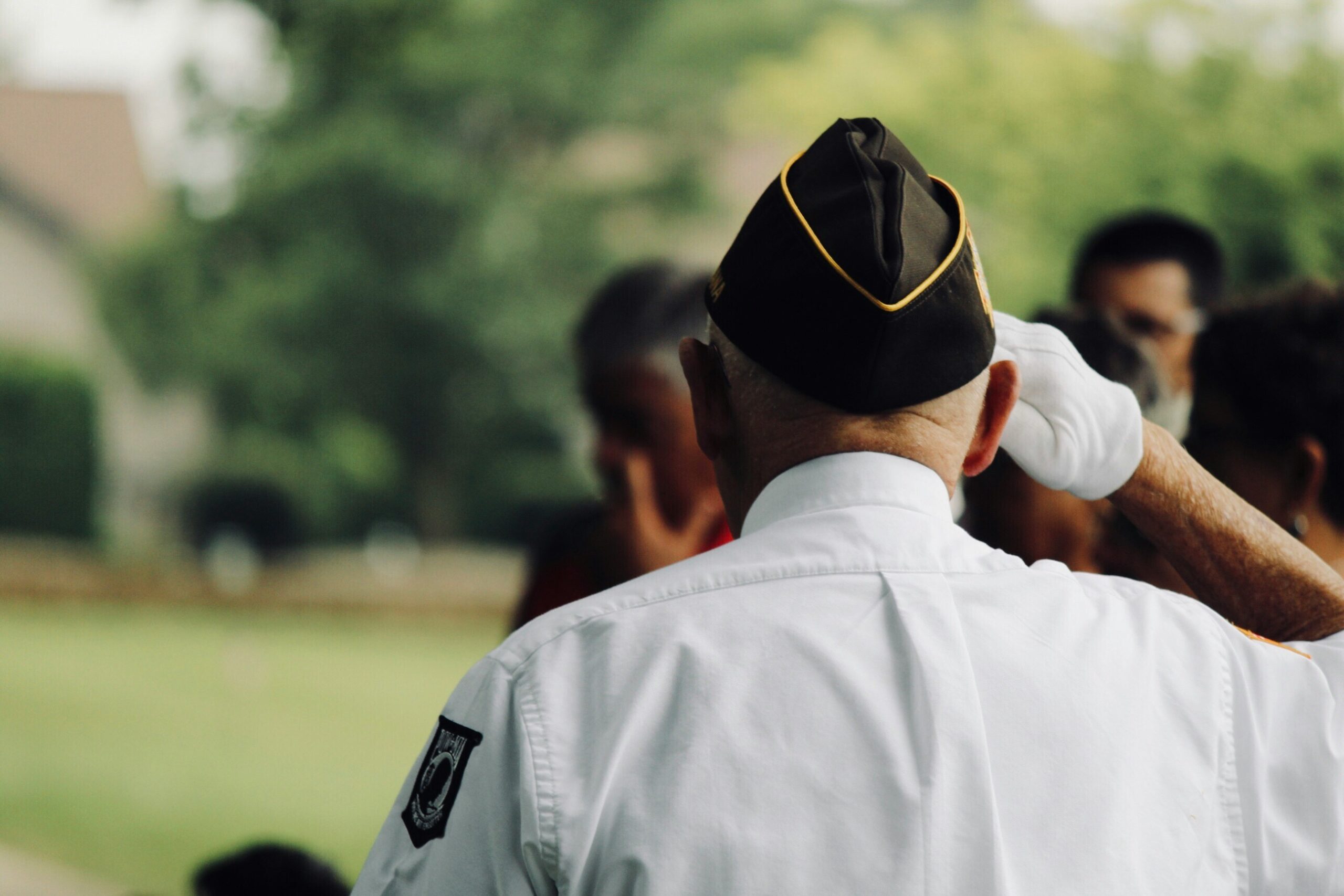 Older male veteran stands saluting