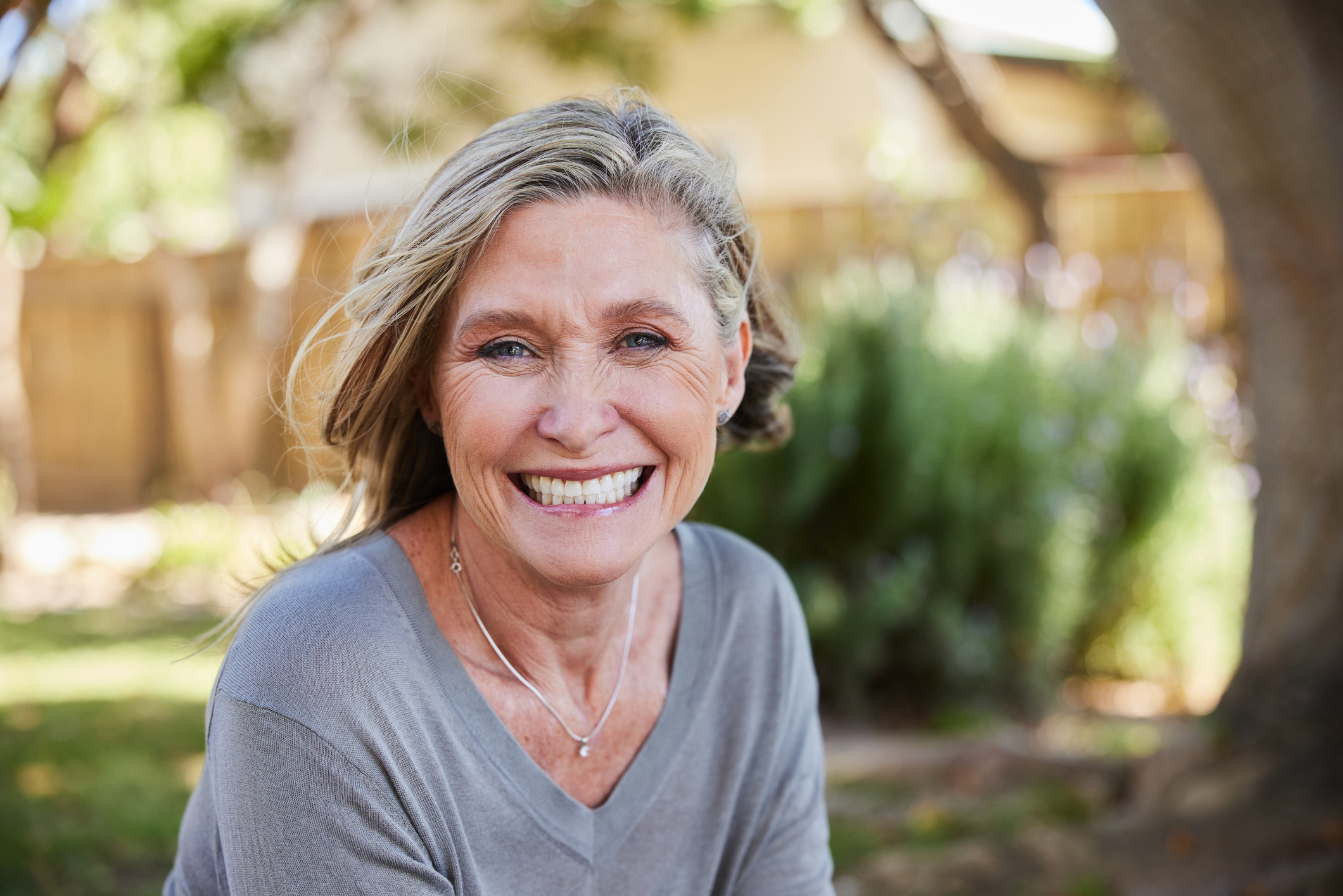 Smiling mature woman sitting in her back yard