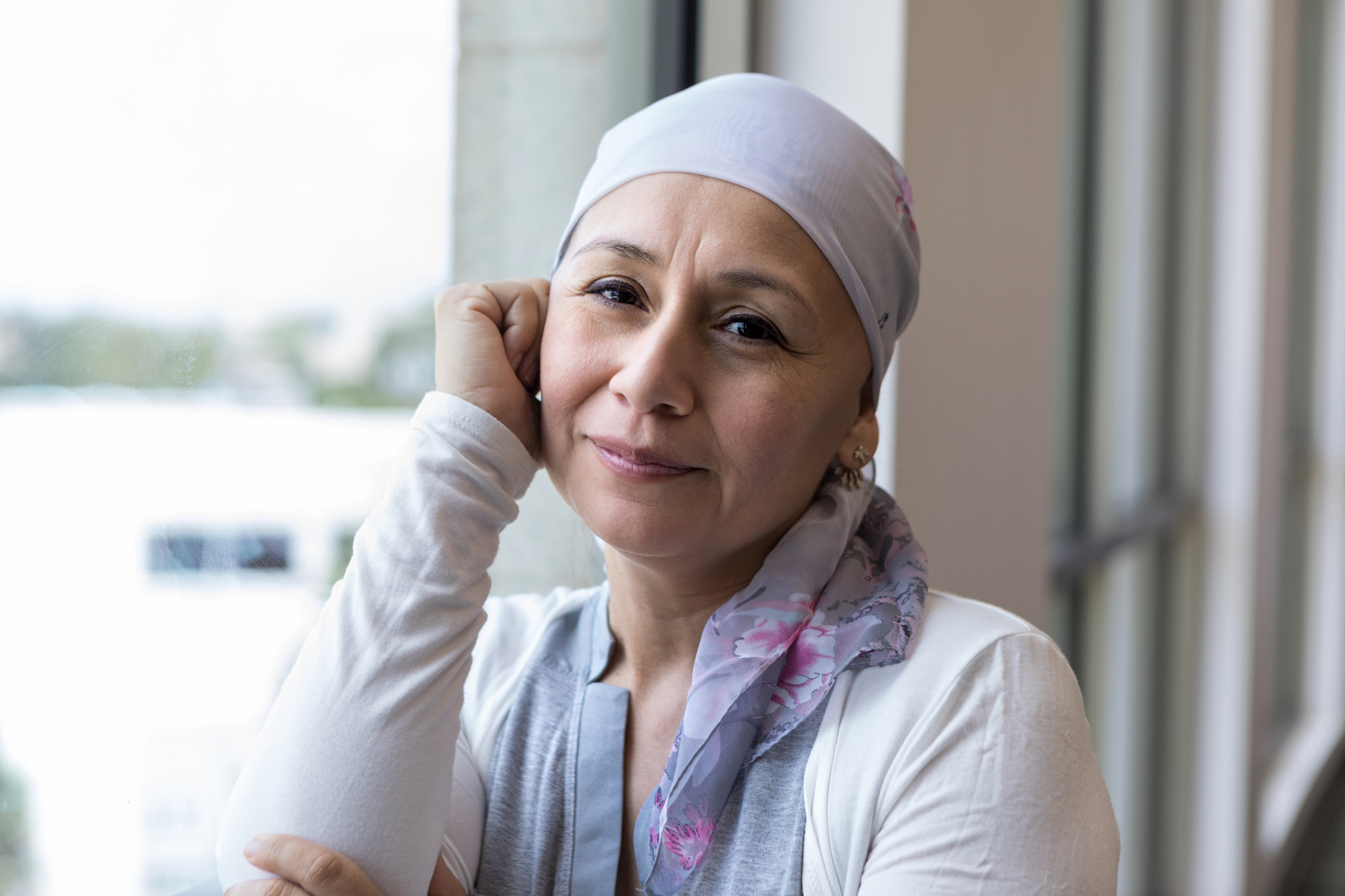 Breast Cancer Survivor poses peacefully by window