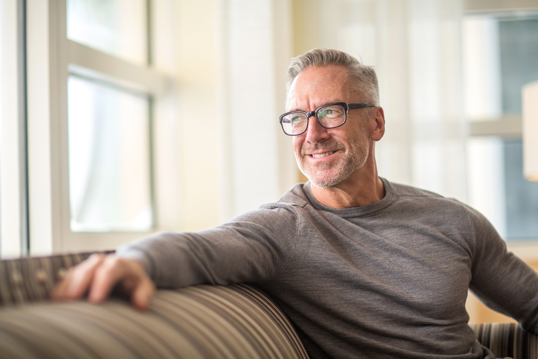 Handsome older man sitting on a sofa