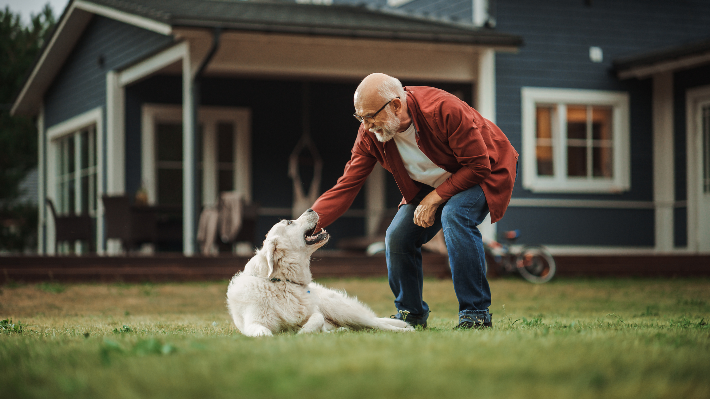 Cheerful Senior Man Enjoying Time Outside with a Pet Dog