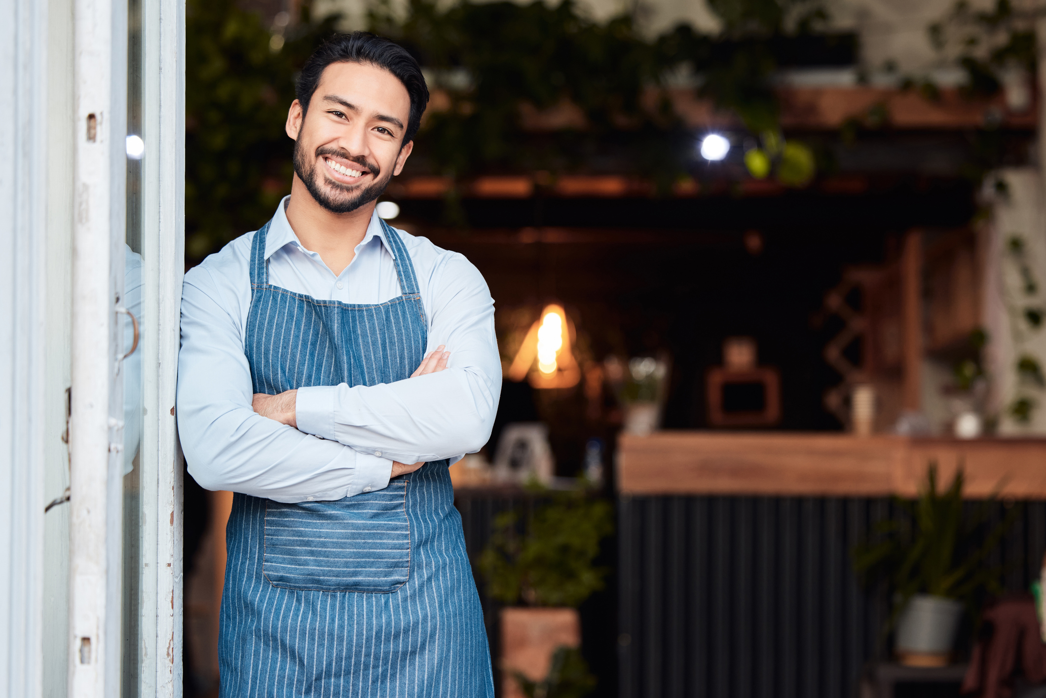 Happy Asian small business owner stands smiling