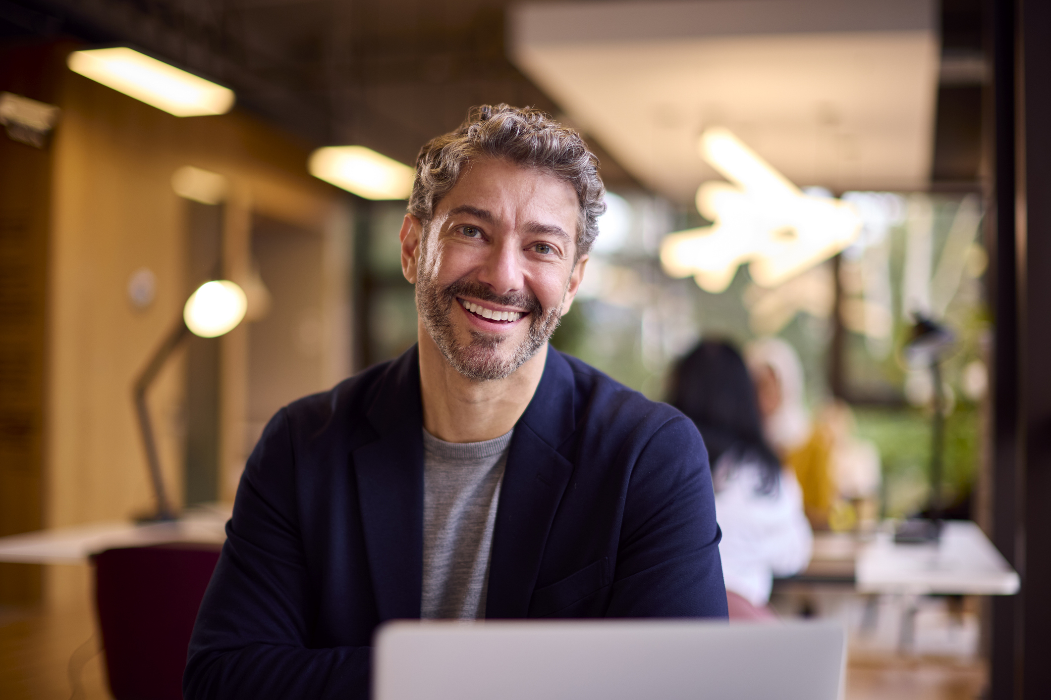 Mature Businessman Working On Laptop At Desk In Office