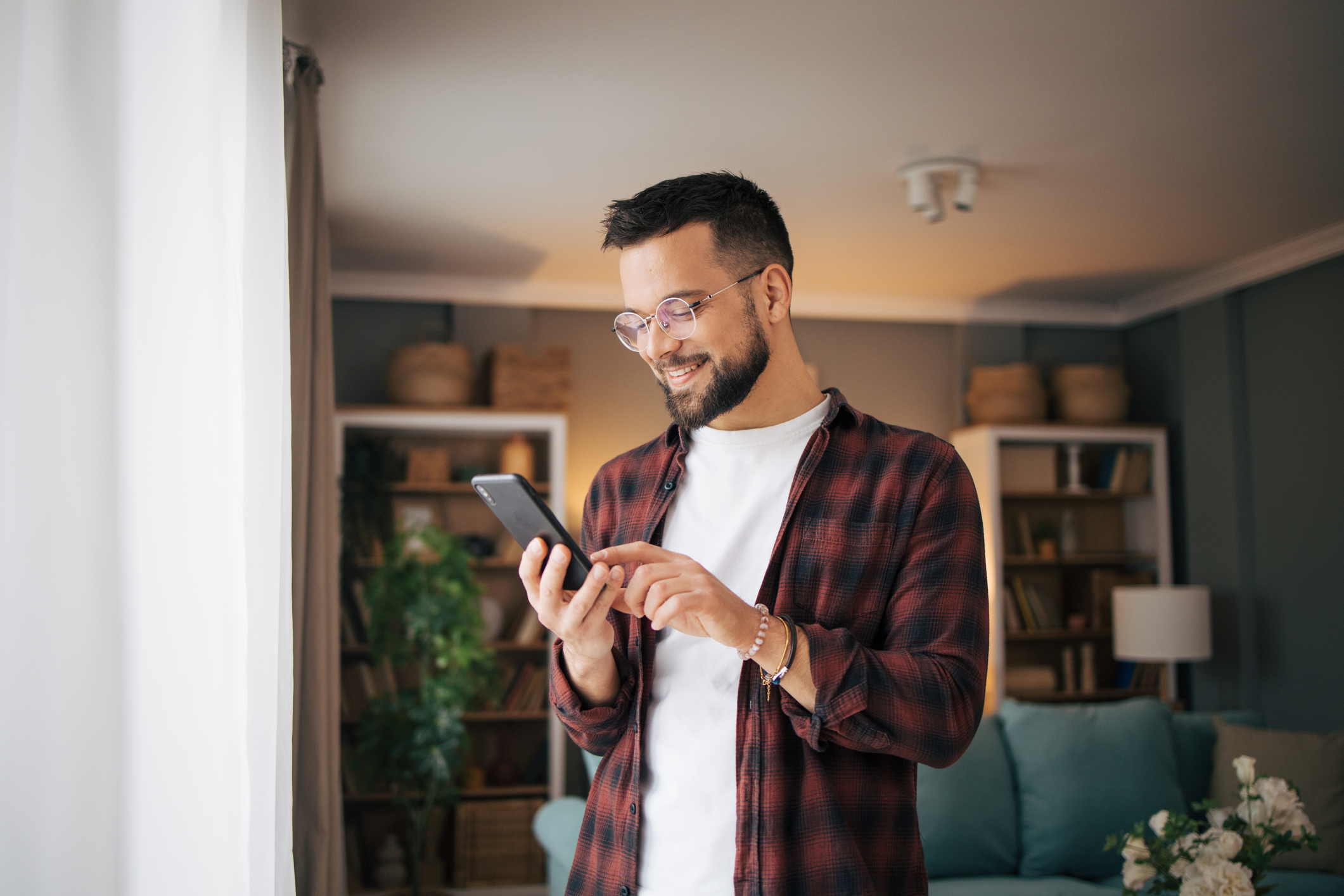 An adult man is using his smartphone.
