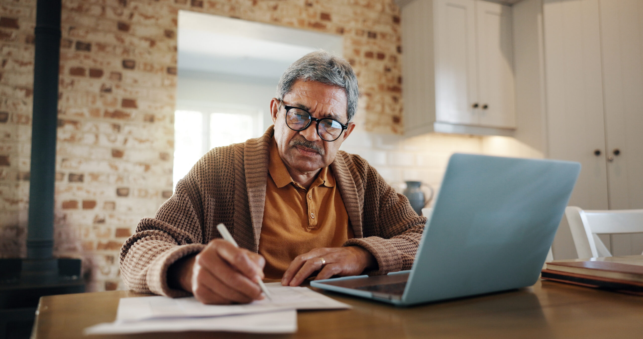 Retired senior man working on financial documents.