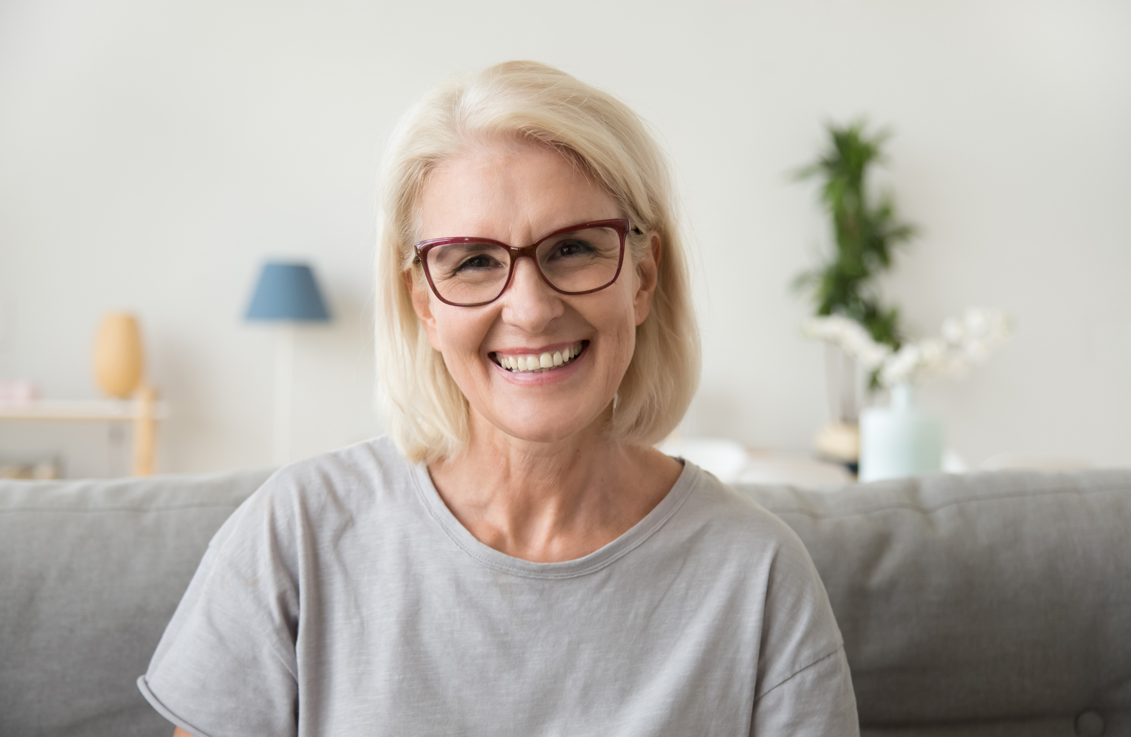 Smiling middle-aged woman sitting at home